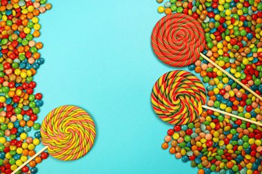  Renkli tatlılar ve mavi arka plan üzerinde lolipop