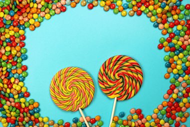  Renkli tatlılar ve mavi arka plan üzerinde lolipop