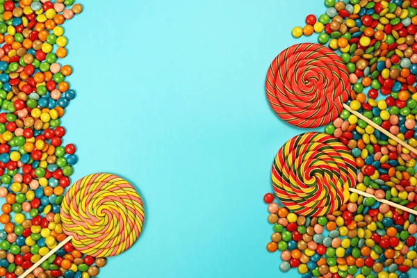  Renkli tatlılar ve mavi arka plan üzerinde lolipop
