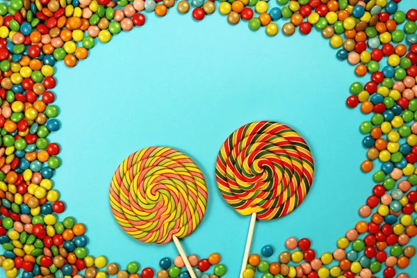  Renkli tatlılar ve mavi arka plan üzerinde lolipop