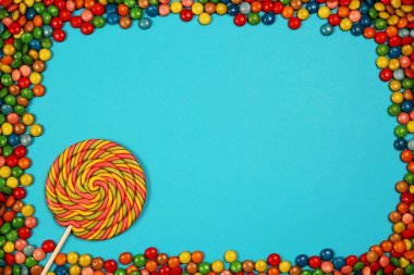 Renkli tatlılar ve mavi arka plan üzerinde lolipop