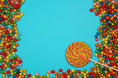 Renkli tatlılar ve mavi arka plan üzerinde lolipop