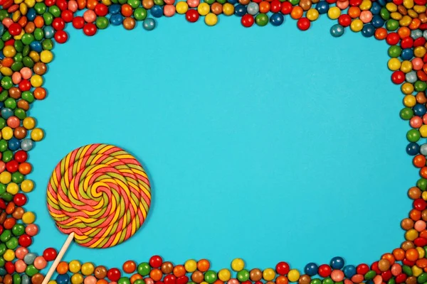 Renkli tatlılar ve mavi arka plan üzerinde lolipop
