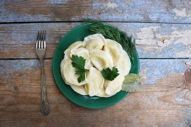 Haşlanmış mantı bir plaka üzerinde. Ahşap rustik arka plan. Üstten Görünüm. Kopya alanı.