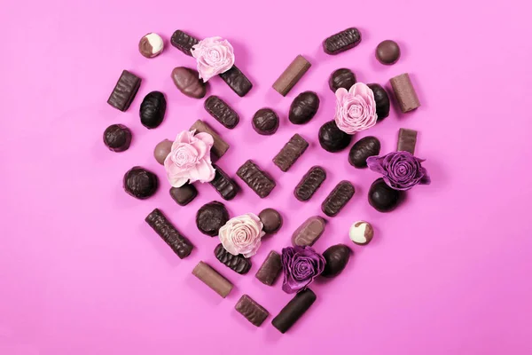День святого Валентина концепция. Шоколадные конфеты и розы на розовом фоне — стоковое фото