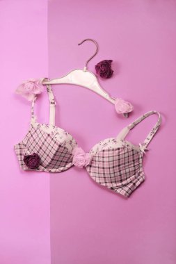 Askı pembe bir arka plan üzerinde sutyen