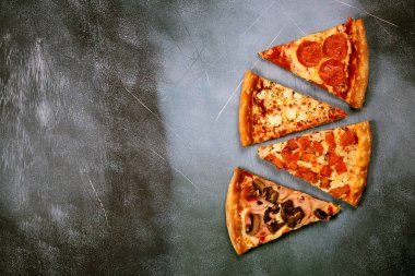 Dilim pizza karanlık dokulu bir arka plan üzerinde farklı dolguları ile