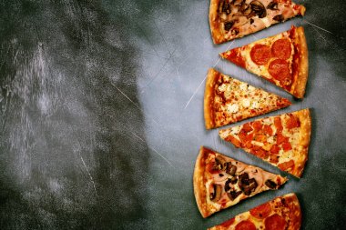 Dilim pizza karanlık dokulu bir arka plan üzerinde farklı dolguları ile