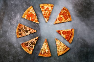 Dilim pizza karanlık dokulu bir arka plan üzerinde farklı dolguları ile