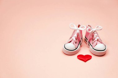 Pembe bir arka plan üzerinde bebek spor ayakkabı