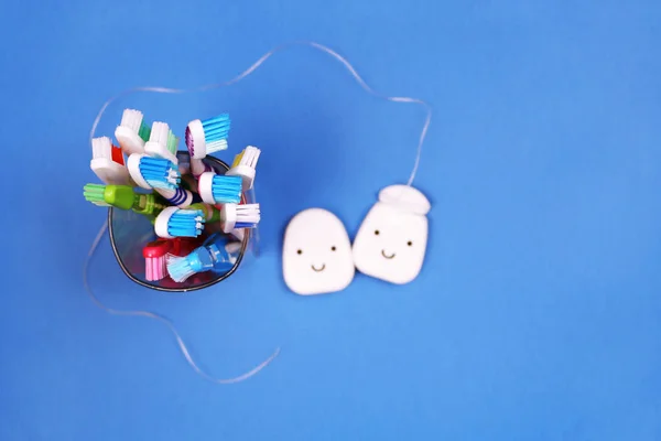 Brosses à dents et fil dentaire sur fond bleu — Photo