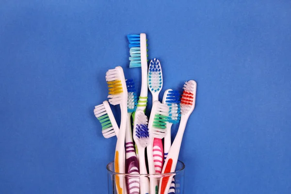 Tandenborstels in glas op blauwe achtergrond — Stockfoto
