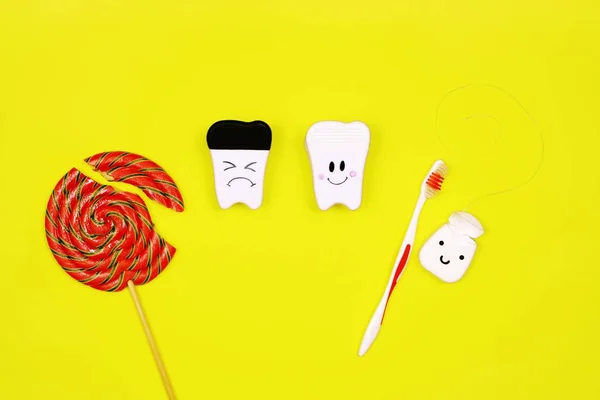 Gesunde und kranke Zähne, Lutscher und Zahnbürste auf gelbem Hintergrund. Konzept zur Zahnreinigung — Stockfoto
