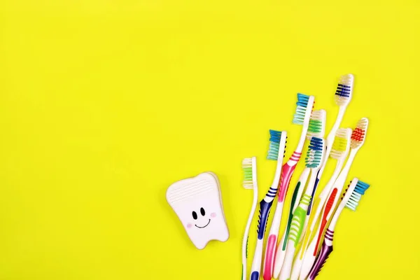 Zahnbürsten und Spielzeugzähne auf gelbem Hintergrund — Stockfoto