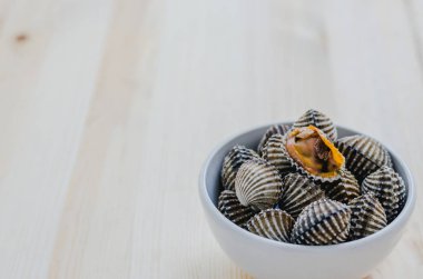 ahşap arka plan üzerinde beyaz kase beyazlatılmış midye buğulama