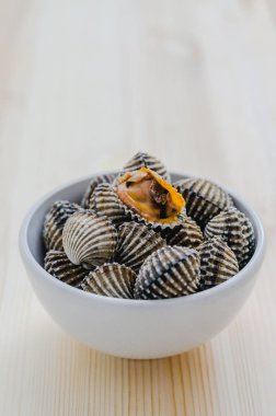 ahşap arka plan üzerinde beyaz kase beyazlatılmış midye buğulama