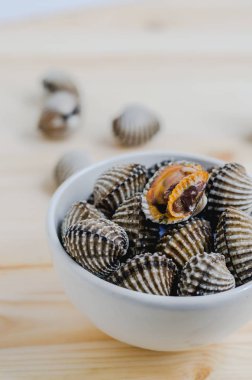 ahşap arka plan üzerinde beyaz kase beyazlatılmış midye buğulama