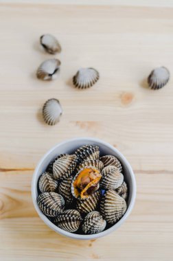ahşap arka plan üzerinde beyaz kase beyazlatılmış midye buğulama