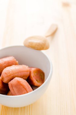 Beyaz kasede şerbetli muz, ahşap arka planda, Tayland tatlısı.