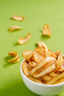 Yeşil masa örtüsü arkaplanda tatlı muz cipsi