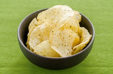 Yeşil masa örtüsü arkaplanındaki patates cipsi cipsi molada atıştırmalık