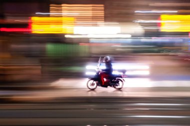 Hızlı büyük bir metropol nightlit sokaklarında çalışan siyah motosiklet