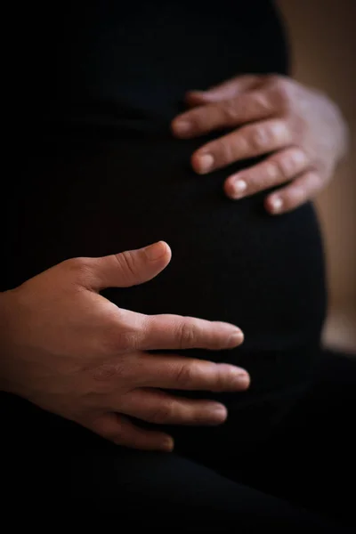 pregnant woman holds her hands on her swollen belly. Love concept.