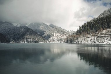 Ritsa Gölü manzarası ve Abhazya 'nın karlı dağları.