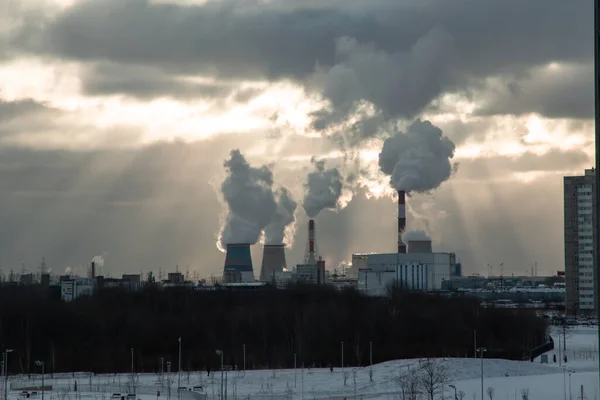 the rays of the sun break through the clouds at dawn above the power plant