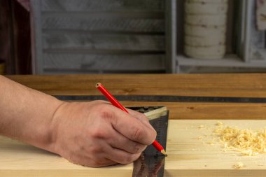 Marangozun tahtayı kurşun kalemle işaretlediği yakın plan görüntü..