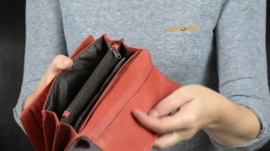 Kız kırmızı bir çanta açar ve içine dolar koyar. Yavaş çekim.