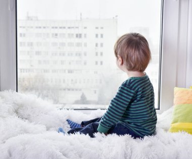 Küçük çocuk pencereden dışarı bakarak 