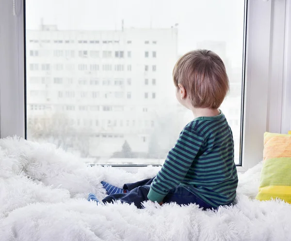 Niño pequeño mirando por la ventana — Foto de Stock