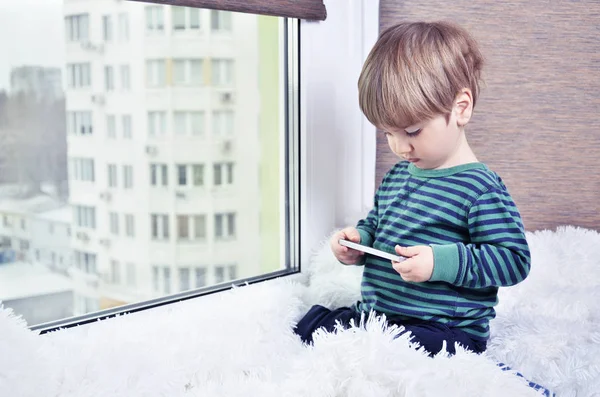 Niño sentado en la ventana — Foto de Stock