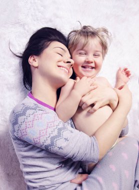 mutlu anne ve sarılma ve yatakta yatarken gülüyor oğlu