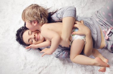mutlu anne ve sarılma ve yatakta yatarken gülüyor oğlu