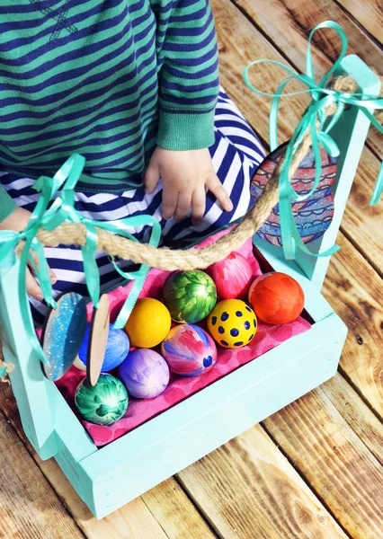 Huevos de Pascua brillantes en una cesta de colores . — Foto de Stock