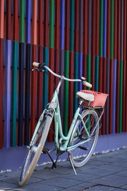 Münih, Almanya - 20 Şubat 2020: Renkli Pinakothek der Moderne 'nin ya da Almanya' nın Münih kentindeki Modern Sanatlar Müzesi 'nin önüne park edilmiş pastel renkli ve sepetli bir retro şehir bisikleti