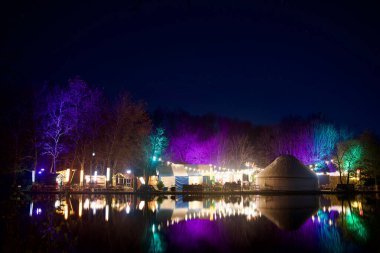 Münih, Almanya - 20 Kasım 2019: Westpark 'taki gölün kenarındaki Gans Am Wasser kafesi, Aralık ayı boyunca renkli bir Noel pazarına dönüşüyor..