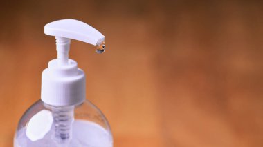 Ahşap arka planda şeffaf el dezenfektanı jeli beyaz, temiz plastik bir şişe, Coronavirus covid-19 konsepti ve el hijyeni.