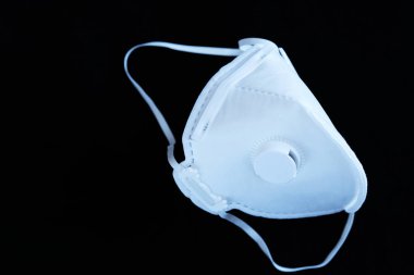 Siyah arka planda kapakçığı olan steril olmayan beyaz bir ffp3 maske. Coronavirus covid-19 kavramı, alerji ve hava kirliliği nedeniyle solunum hastalıkları