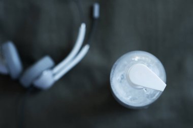 Şeffaf el dezenfektanı jeli, siyah arka planda kulaklığı olan temiz, beyaz bir plastik şişe. Coronavirus covid-19 konsepti, ana ofis ve tele-çalışma, hapsedilme ve karantina.