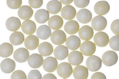 Pastel sarı şeker kaplı çikolata şekeri. Küre şeklinde.