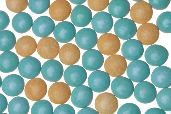 Pastel portakal ve yeşil şeker kaplı çikolata şekeri. Küre şeklinde.