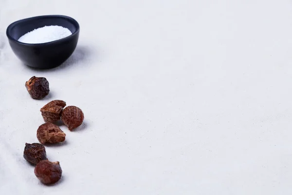 Soapberry kabukları (Sapindus saponaria) ve soda perkarbonatı bej renkli organik pamuk kumaş üzerinde fotokopi alanı ile aynı hizada.