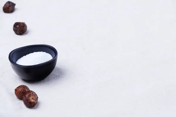Soapberry kabukları (Sapindus saponaria) ve soda perkarbonatı bej renkli organik pamuk kumaş üzerinde fotokopi alanı ile aynı hizada.