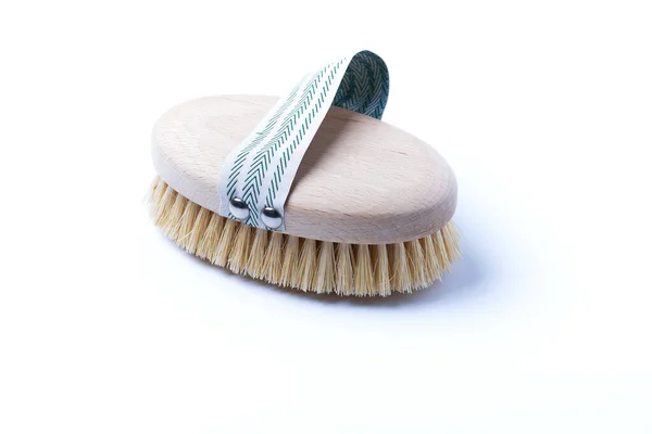 Natural wooden brush for dry body brushing on a white background