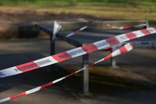 Oyun parkındaki masa tenisi masasında asılı duran bir polis kordonu eğlence aktivitelerinin yasaklanmasının ardından Cvid-19 nedeniyle risk altında. Kolluk kuvvetleri, salgın, polis kısıtlaması ve suç mahalli kavramı