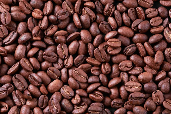 Kavrulmuş Arabika kahve çekirdekleri (cafa arabica) siyah desenli karton arka planda izole edilmiş bir sırada. Sağlıklı beslenme kavramı, enerjik içecek, organik doğal, grafikler