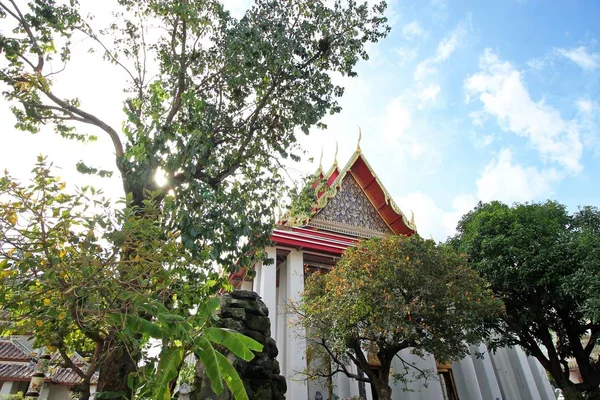 Bangkok-Thailand: voorgrond bomen en Thaise architectuur aan de openbare tempel Wat Pho op 22 oktober 2016 — Stockfoto